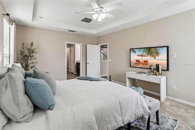 bedroom featuring carpet floors, a tray ceiling, and ceiling fan