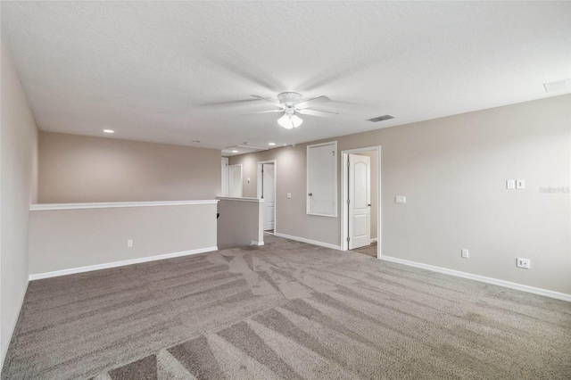 carpeted empty room with a textured ceiling and ceiling fan