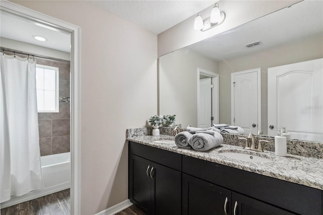 bathroom featuring shower / tub combo with curtain, vanity, a textured ceiling, and wood-type flooring