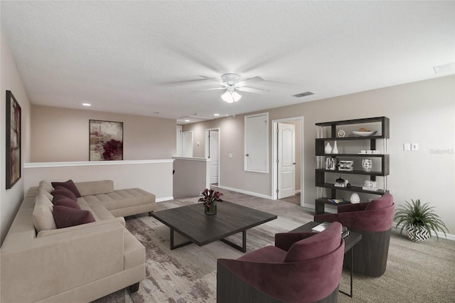 living room featuring a textured ceiling, light colored carpet, and ceiling fan