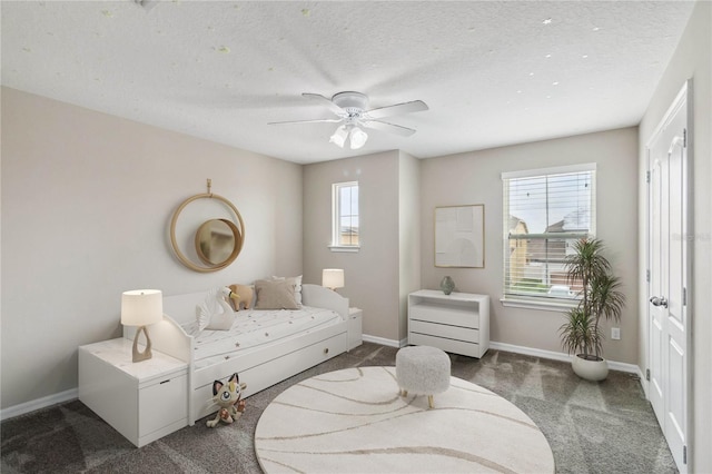 living area with a textured ceiling, carpet flooring, and ceiling fan