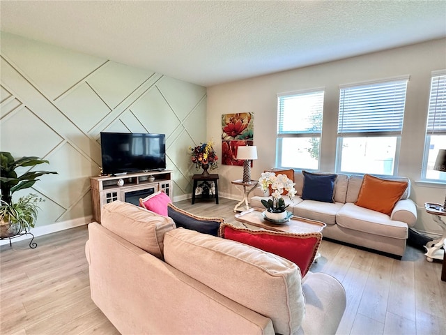 living room featuring light hardwood / wood-style flooring and a textured ceiling