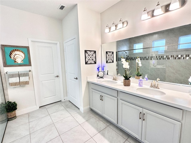 bathroom featuring vanity, a tile shower, and tile patterned flooring