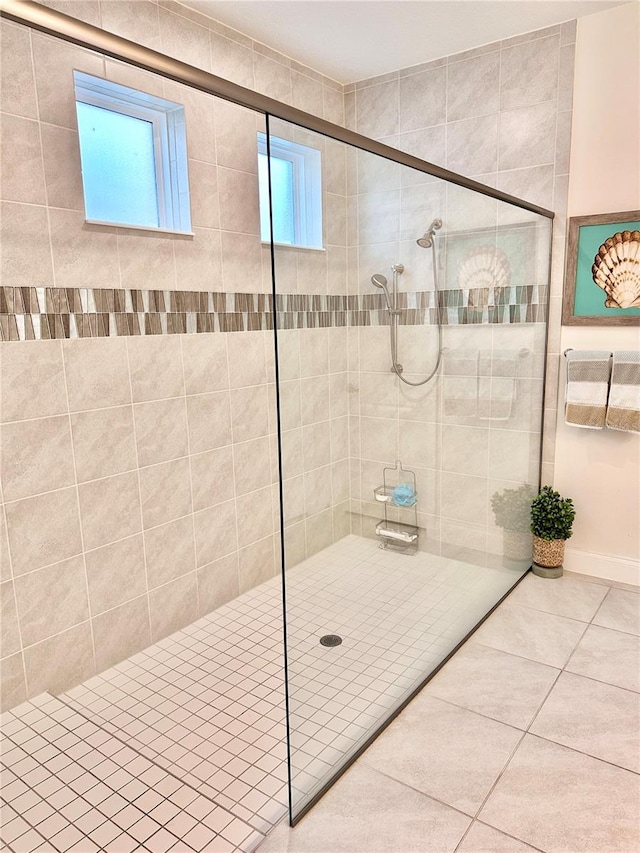 bathroom with a shower with door, tile patterned floors, and plenty of natural light