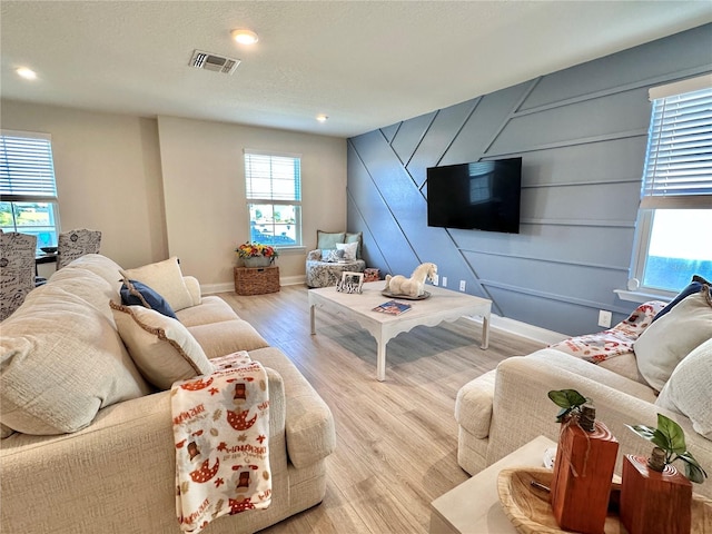 living room featuring light hardwood / wood-style flooring and a textured ceiling