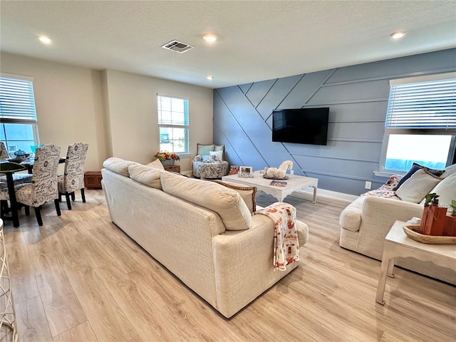 living room featuring a textured ceiling and light hardwood / wood-style floors