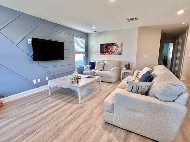 living room featuring light hardwood / wood-style floors and a textured ceiling