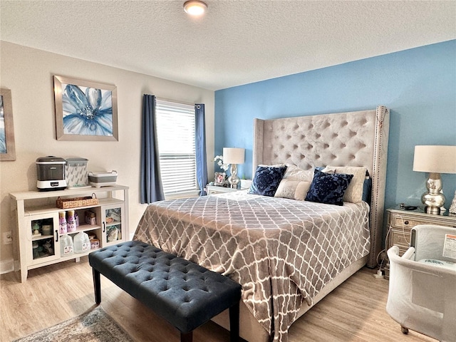 bedroom featuring a textured ceiling and light wood-type flooring