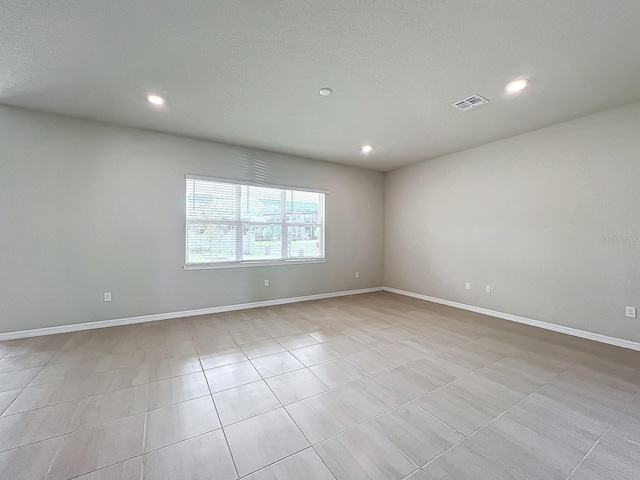 unfurnished room with a textured ceiling