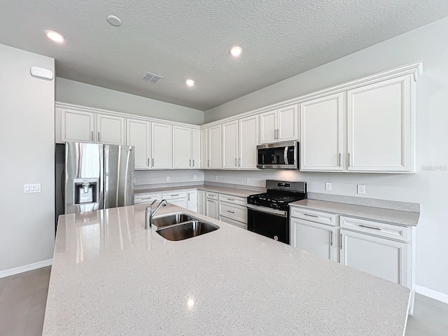 kitchen with stainless steel appliances, sink, and white cabinets