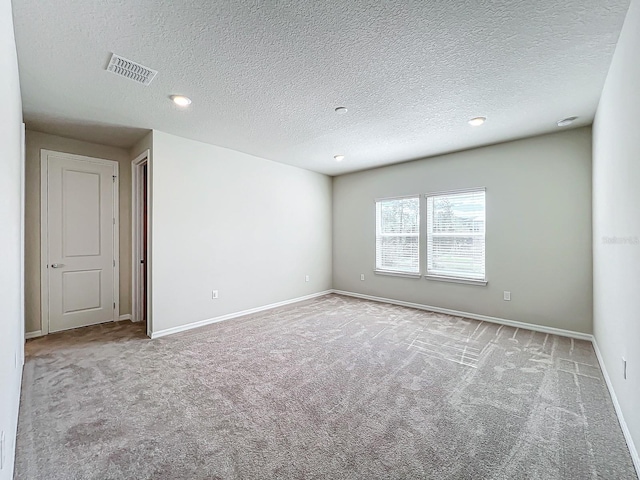 unfurnished room with light carpet and a textured ceiling