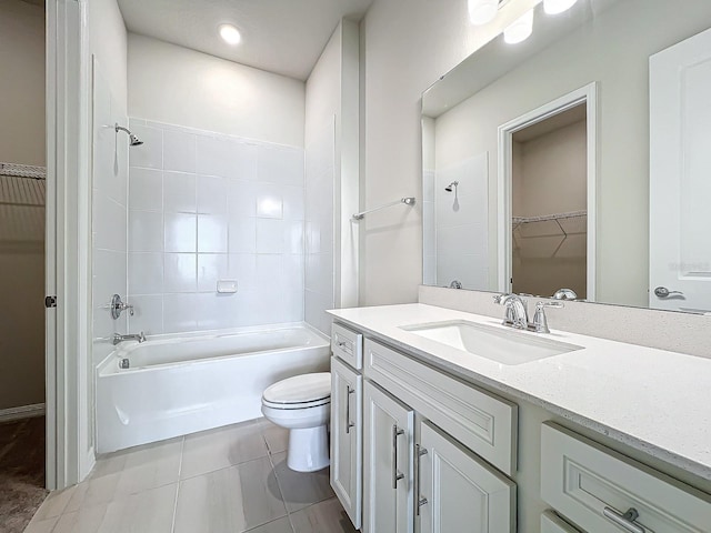 full bathroom with vanity, tiled shower / bath combo, toilet, and tile patterned flooring