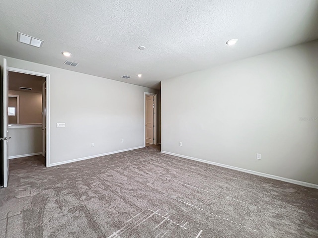 carpeted spare room featuring a textured ceiling