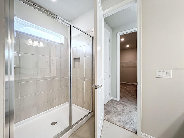 bathroom with walk in shower and tile patterned flooring