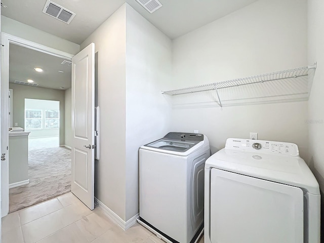 laundry room featuring washer and dryer and light colored carpet