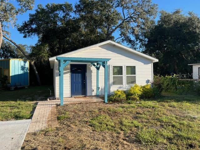 bungalow featuring a shed and a front lawn