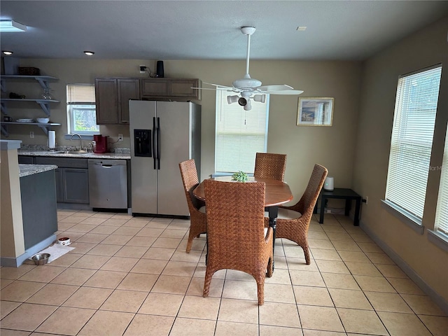 dining area featuring ceiling fan, a healthy amount of sunlight, sink, and light tile patterned floors