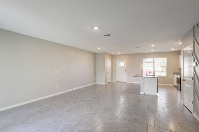 unfurnished room featuring light tile patterned flooring and sink