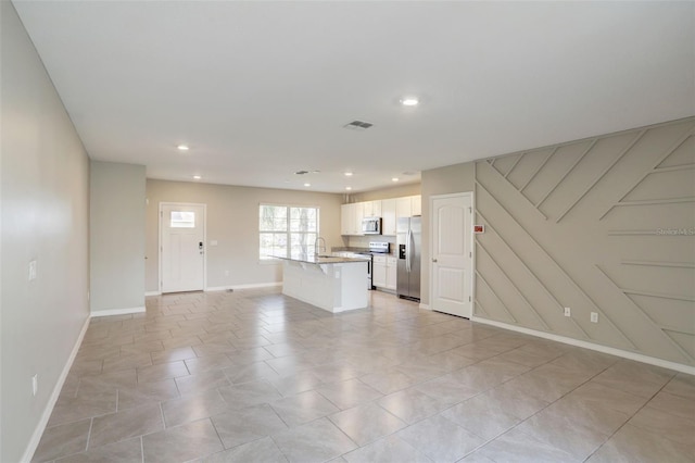 unfurnished living room featuring sink and light tile patterned flooring