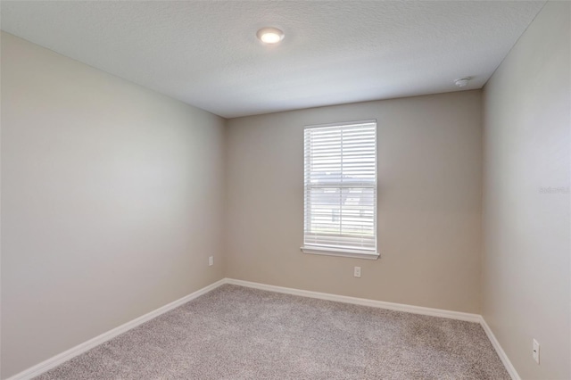 carpeted spare room with a textured ceiling