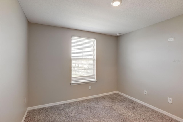 unfurnished room with a textured ceiling and carpet flooring