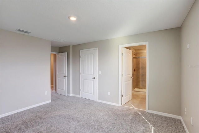 unfurnished bedroom with light carpet, ensuite bathroom, and a closet