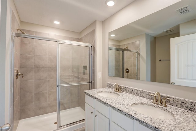 bathroom with vanity and a shower with door