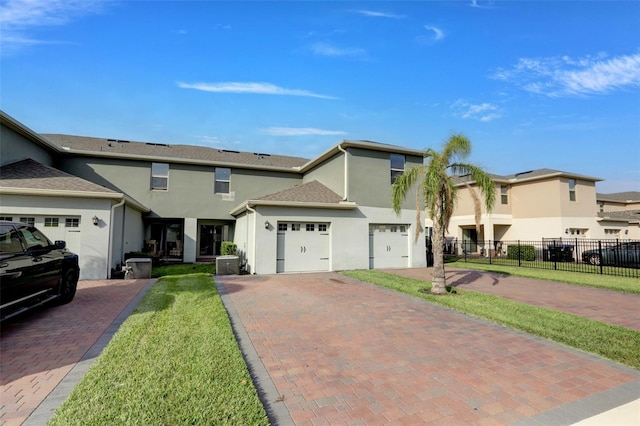 view of front of house with central AC, a garage, and a front lawn