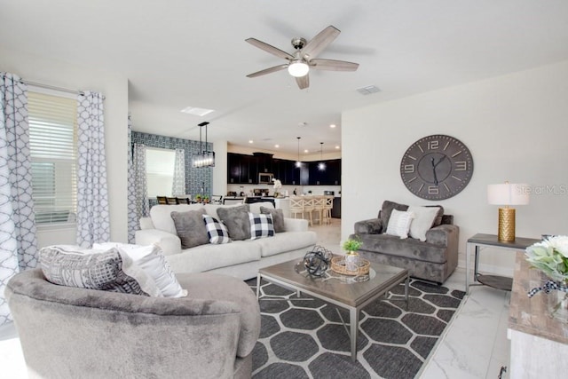 living room with ceiling fan with notable chandelier