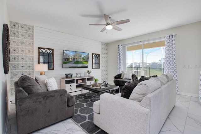 living room with ceiling fan and wood walls