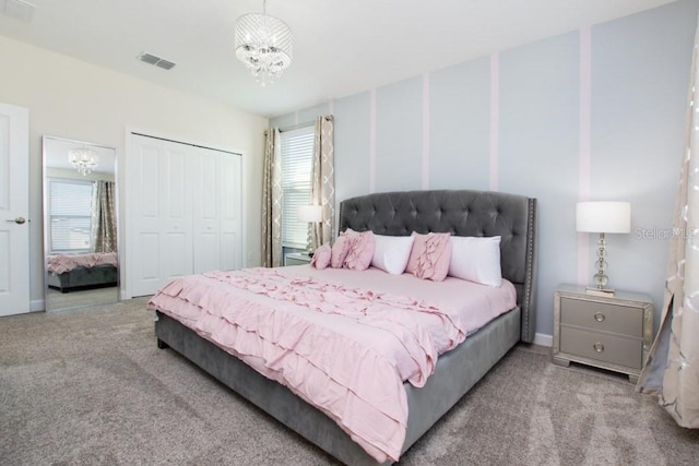 carpeted bedroom with an inviting chandelier, multiple windows, and a closet