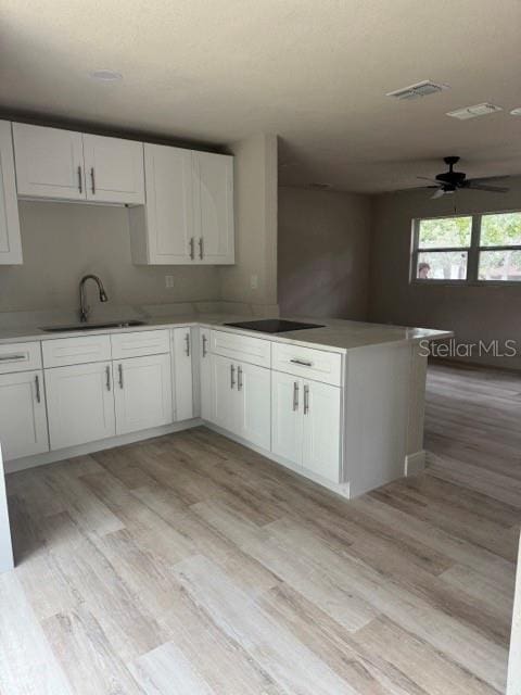 kitchen featuring sink, white cabinets, kitchen peninsula, and ceiling fan