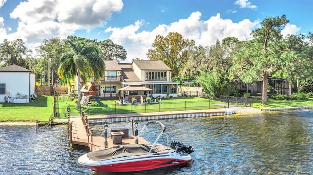 view of dock with a yard and a water view