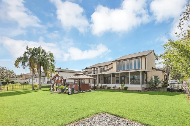 back of property with a gazebo, a lawn, and a sunroom