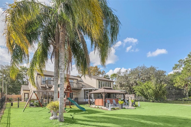 back of house with a gazebo, a patio area, a playground, and a yard