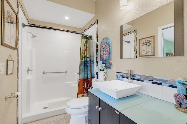 bathroom with vanity, walk in shower, toilet, and backsplash