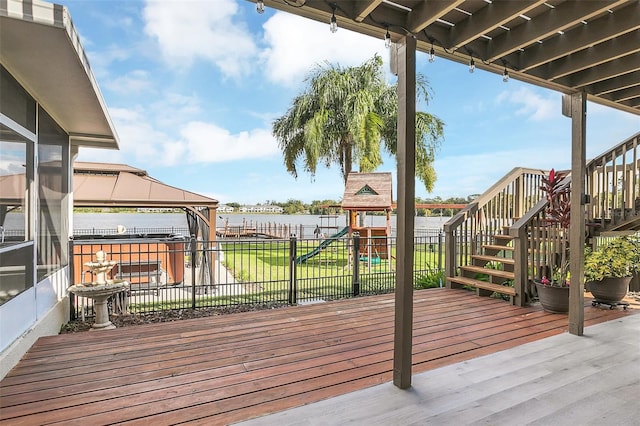 deck with a water view, a gazebo, and a playground