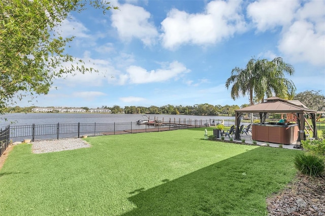 view of yard with a hot tub, a gazebo, and a water view