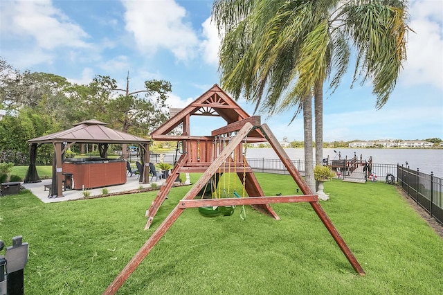 view of playground with a gazebo, a water view, and a lawn