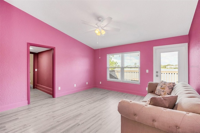 living room with ceiling fan, lofted ceiling, and light hardwood / wood-style flooring