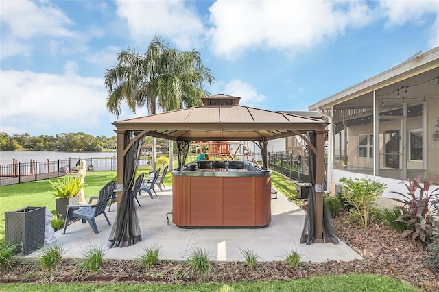 view of patio featuring a hot tub, a gazebo, and a water view