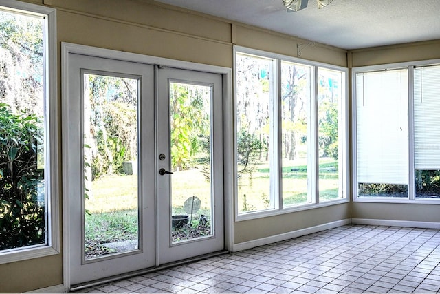 doorway to outside with light tile patterned flooring, a textured ceiling, and french doors