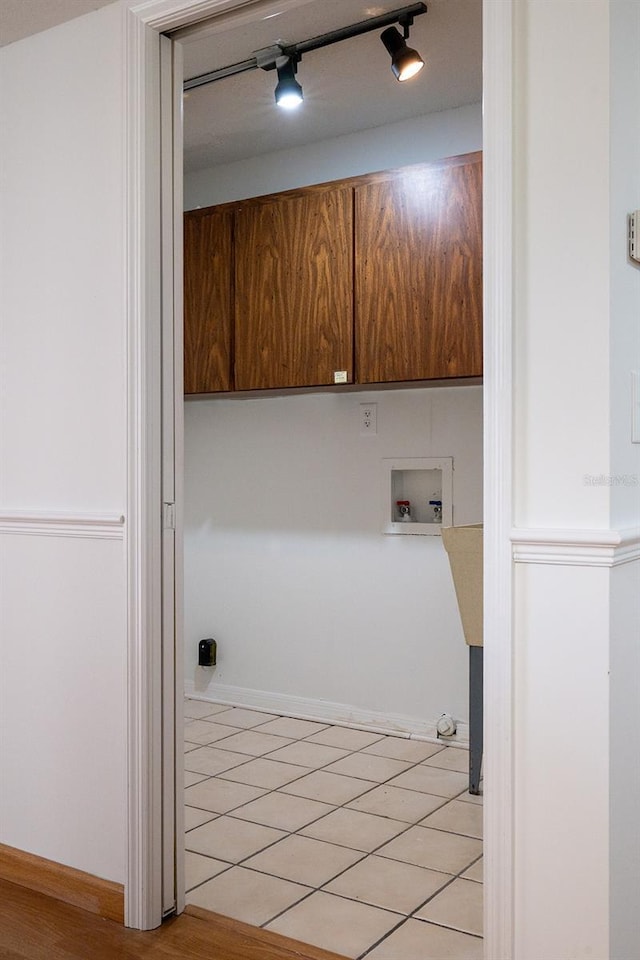 laundry area featuring washer hookup, track lighting, and cabinets