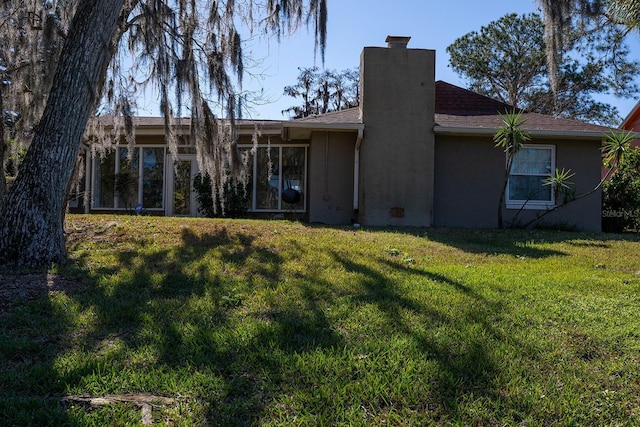 rear view of property with a yard