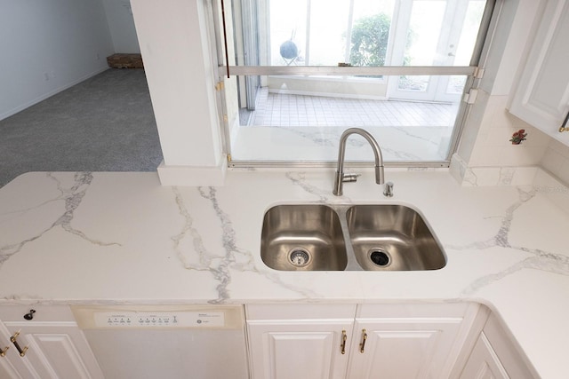 room details featuring sink, dishwasher, carpet floors, light stone countertops, and white cabinets