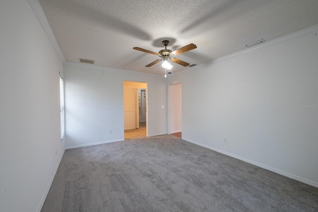 spare room featuring ceiling fan, ornamental molding, a textured ceiling, and carpet flooring