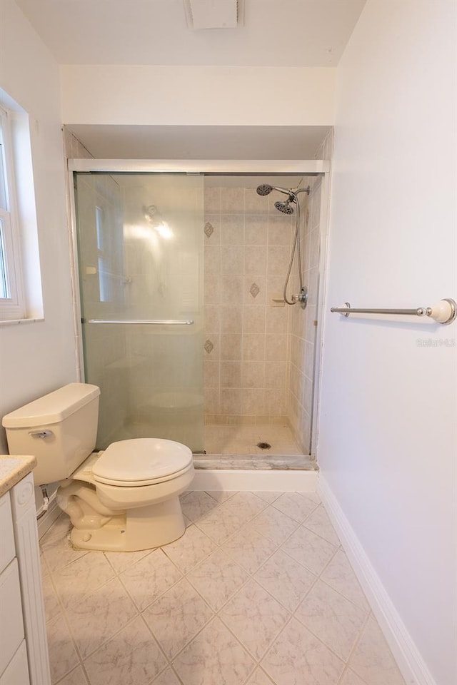 bathroom with an enclosed shower, vanity, and toilet