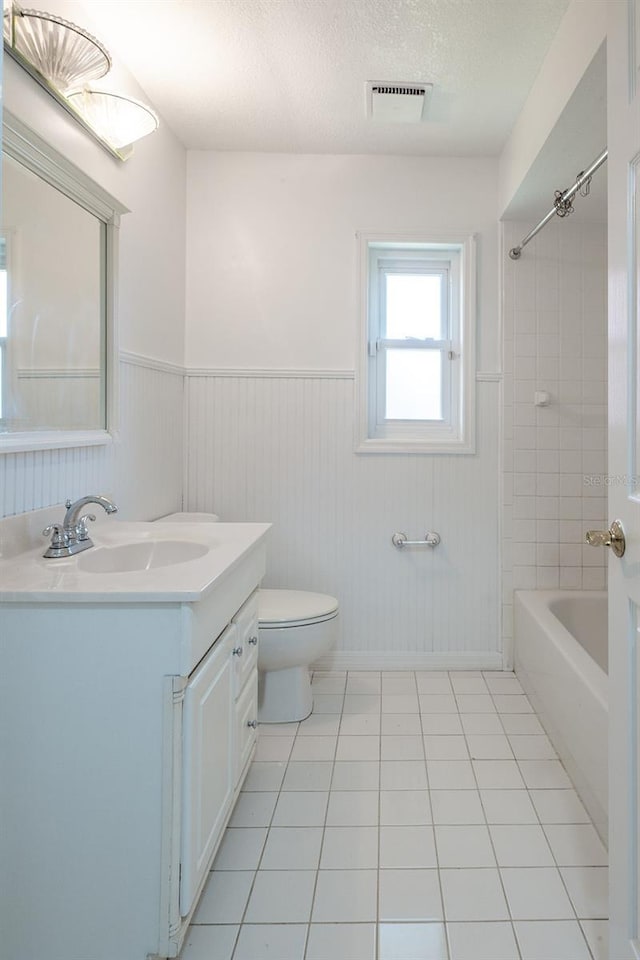 full bathroom with vanity, a textured ceiling, tile patterned floors, and toilet