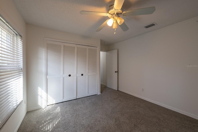 unfurnished bedroom with a closet, carpet, and multiple windows