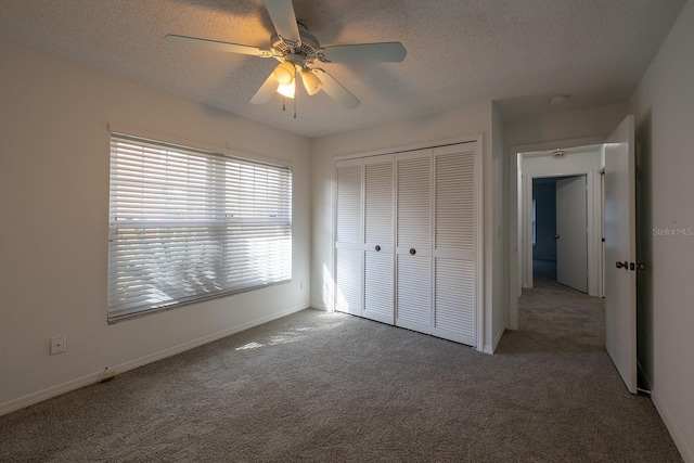 unfurnished bedroom with ceiling fan, carpet floors, a textured ceiling, and a closet